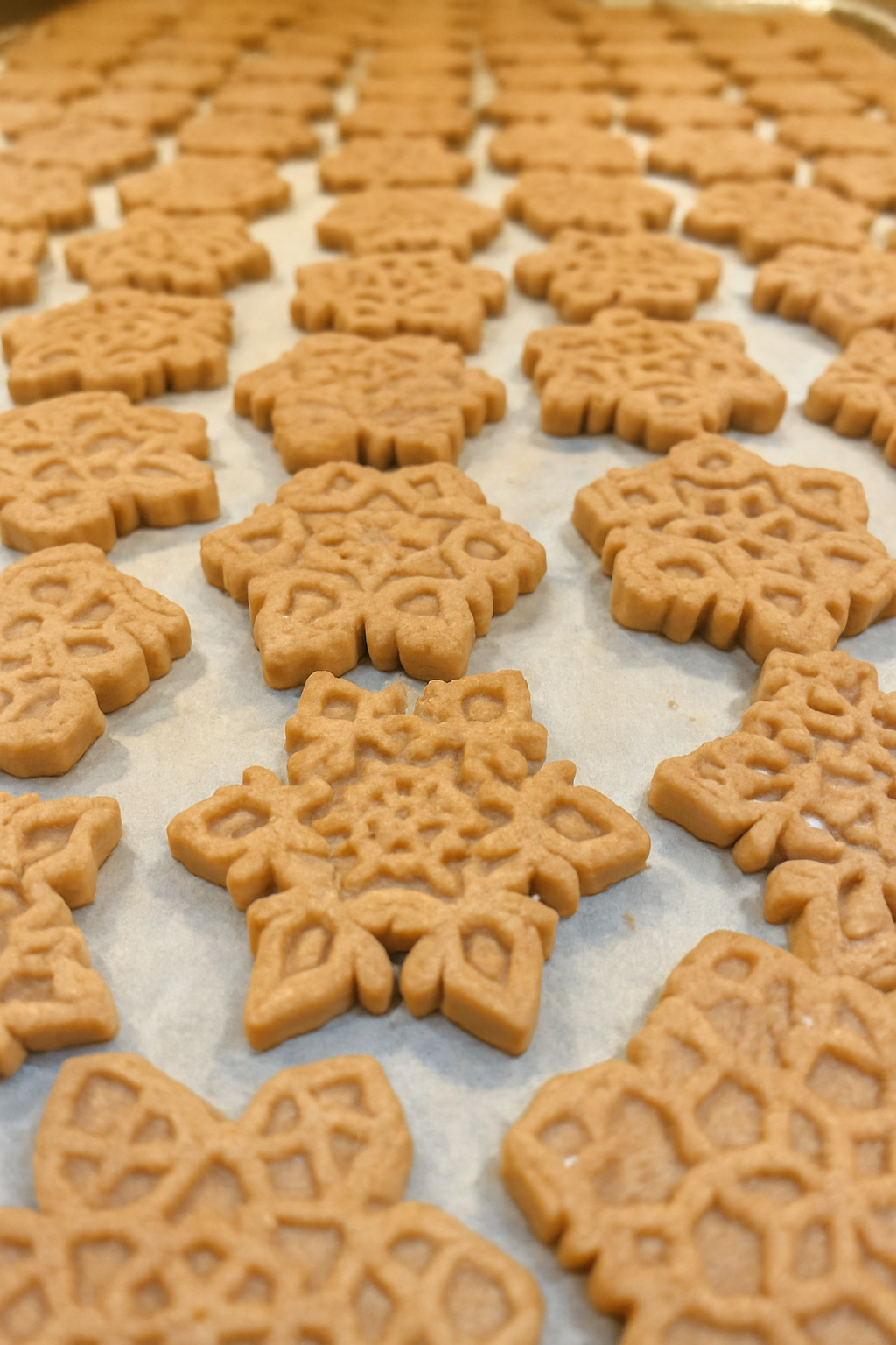 Peanut Butter Snowflakes. Handmade organic holiday dog treats from The Chosen Spot K9 Kitchen layed out on a cookie sheet.