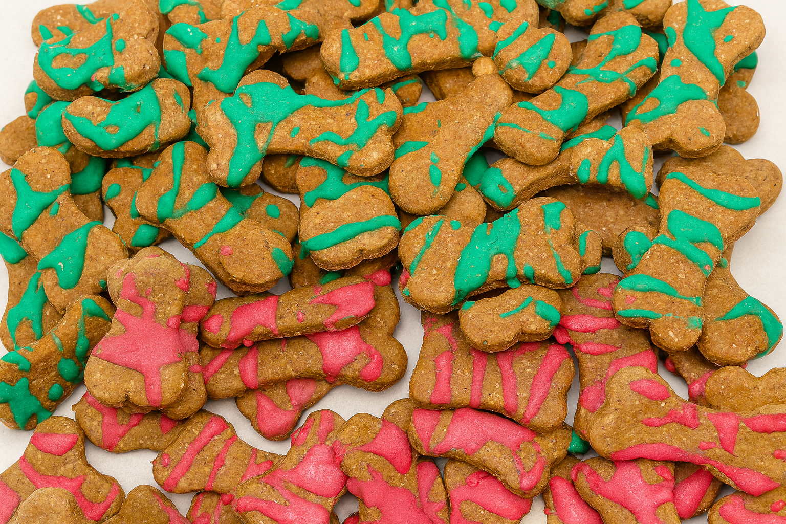 Santa's Dipped Peanut Butter Bones. Handmade organic dog treats from The Chosen Spot K9 Kitchen up close on a white background.