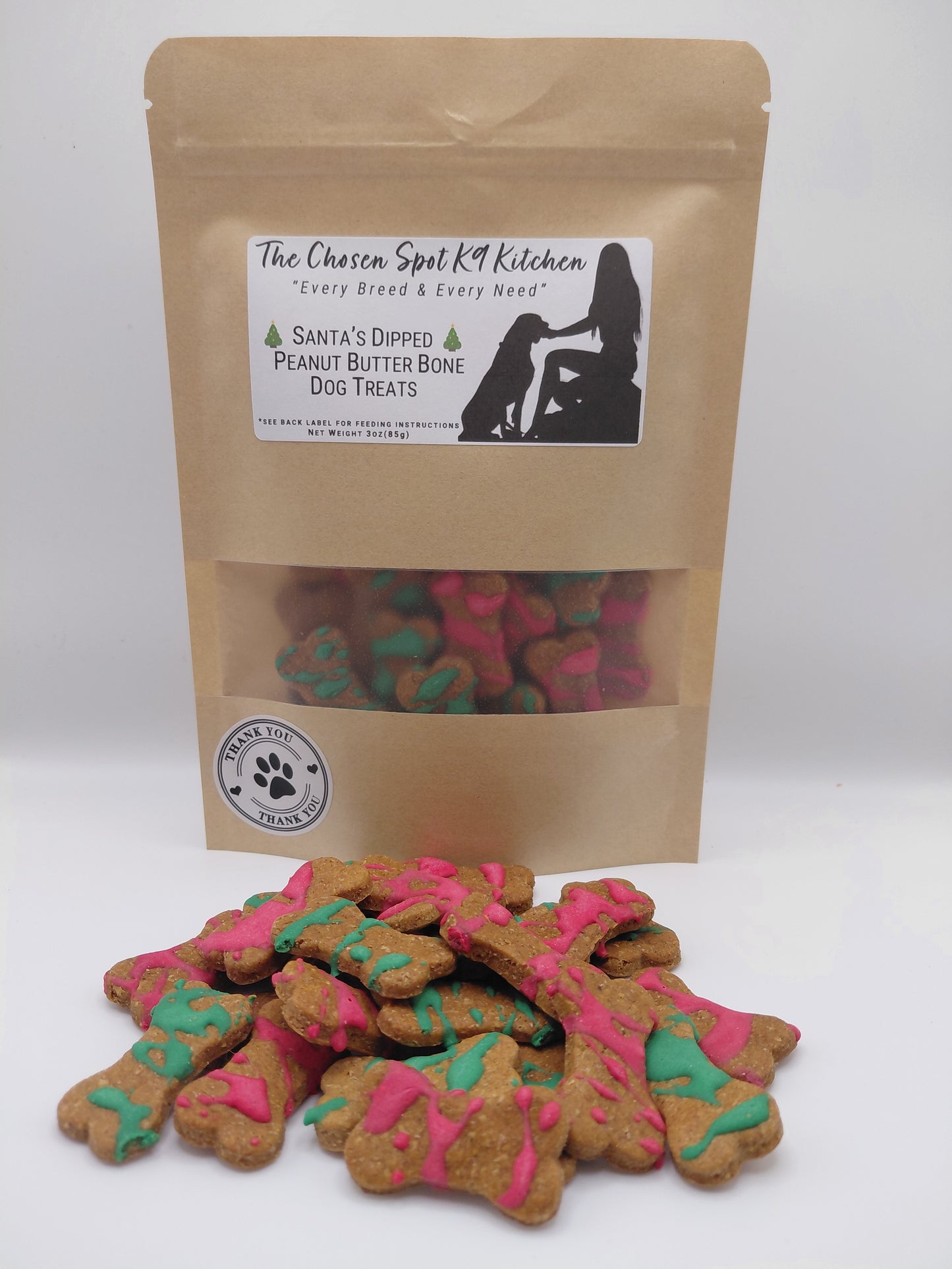 Package of Santa's Dipped Peanut Butter Bones. Handmade organic dog treats from The Chosen Spot K9 Kitchen up close on a white background.