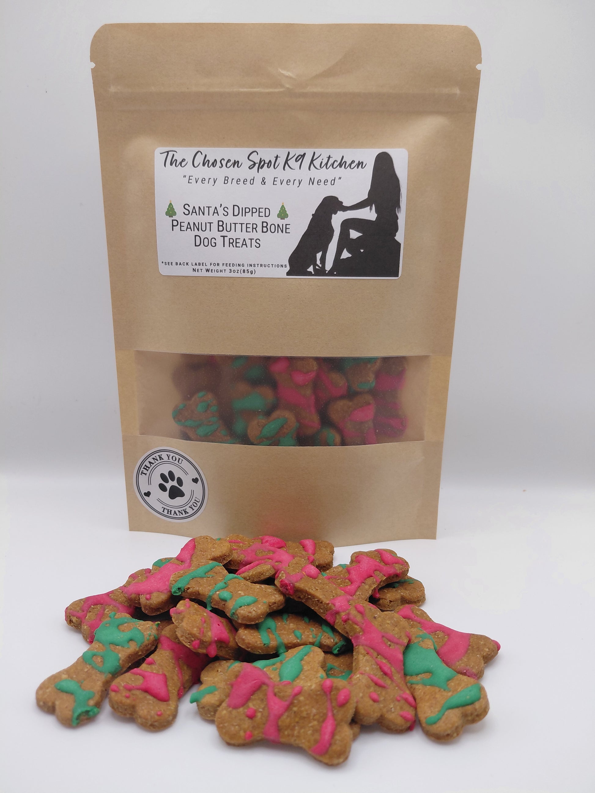 Package of Santa's Dipped Peanut Butter Bones. Handmade organic dog treats from The Chosen Spot K9 Kitchen up close on a white background.